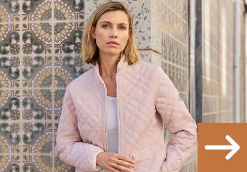 Frau mit rosa Steppjacke und einer beigen Stoffhose.