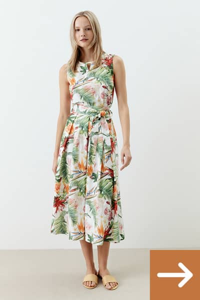 Frau trägt ein langes Sommerkleid mit sehr modischem floralen Druck.