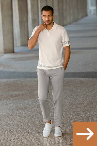 Ein Mann trägt ein weißes Polo-Shirt und eine graue Chino-Hose.