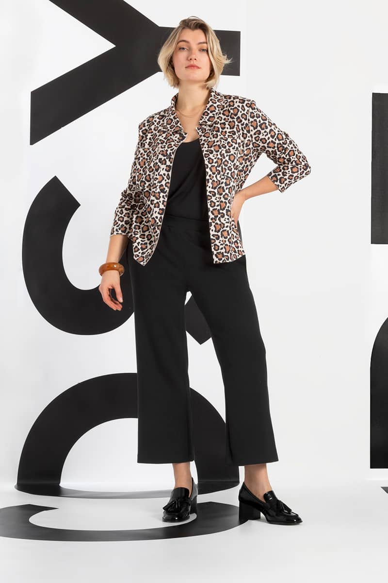 Frau in schwarzer Stoff Kombi mit Blazer in Leopardenlook